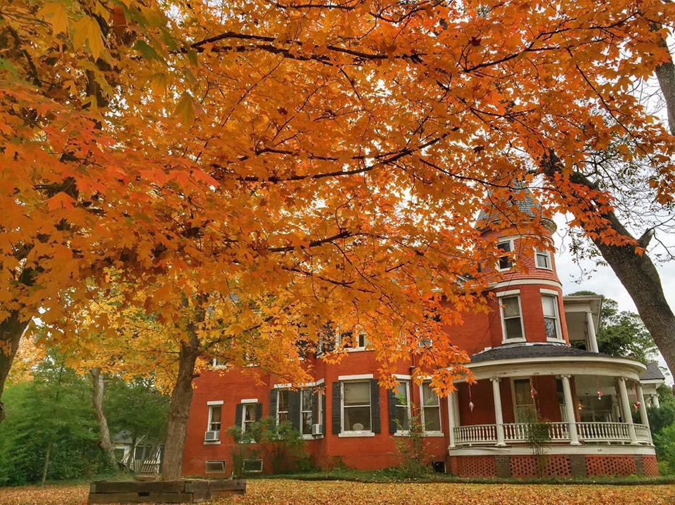 Fall Foliage showing in front of red brick home.